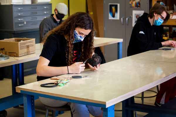 girl sitting at desk working on art