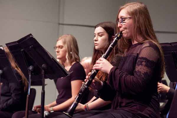 three girls playing instruments in a band