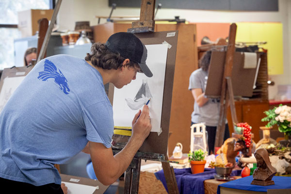 student working on a drawing in art class