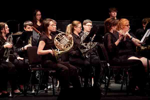 three girls playing instruments in a band